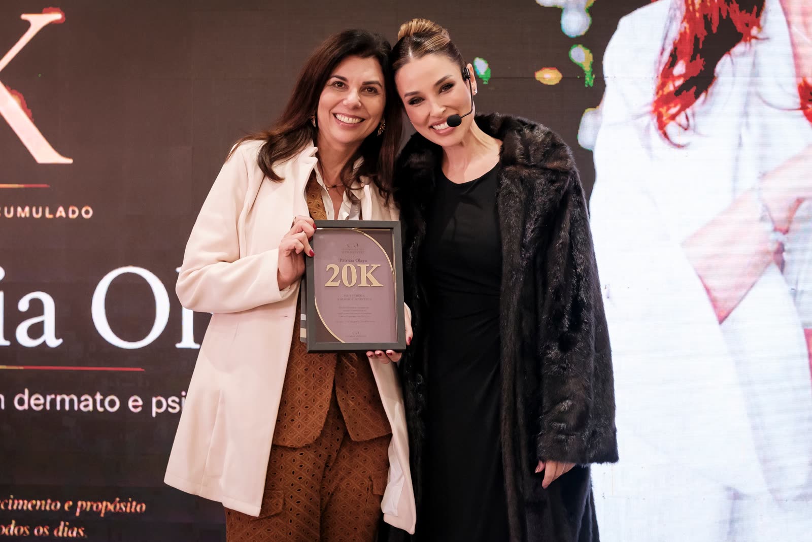 Patrícia Olaya recebendo o reconhecimento de 20K com a Fernanda